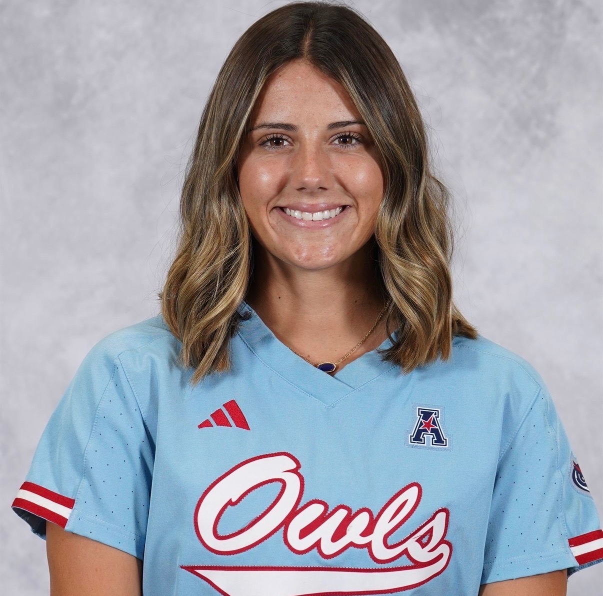 Smiling young woman in light blue Owls jersey