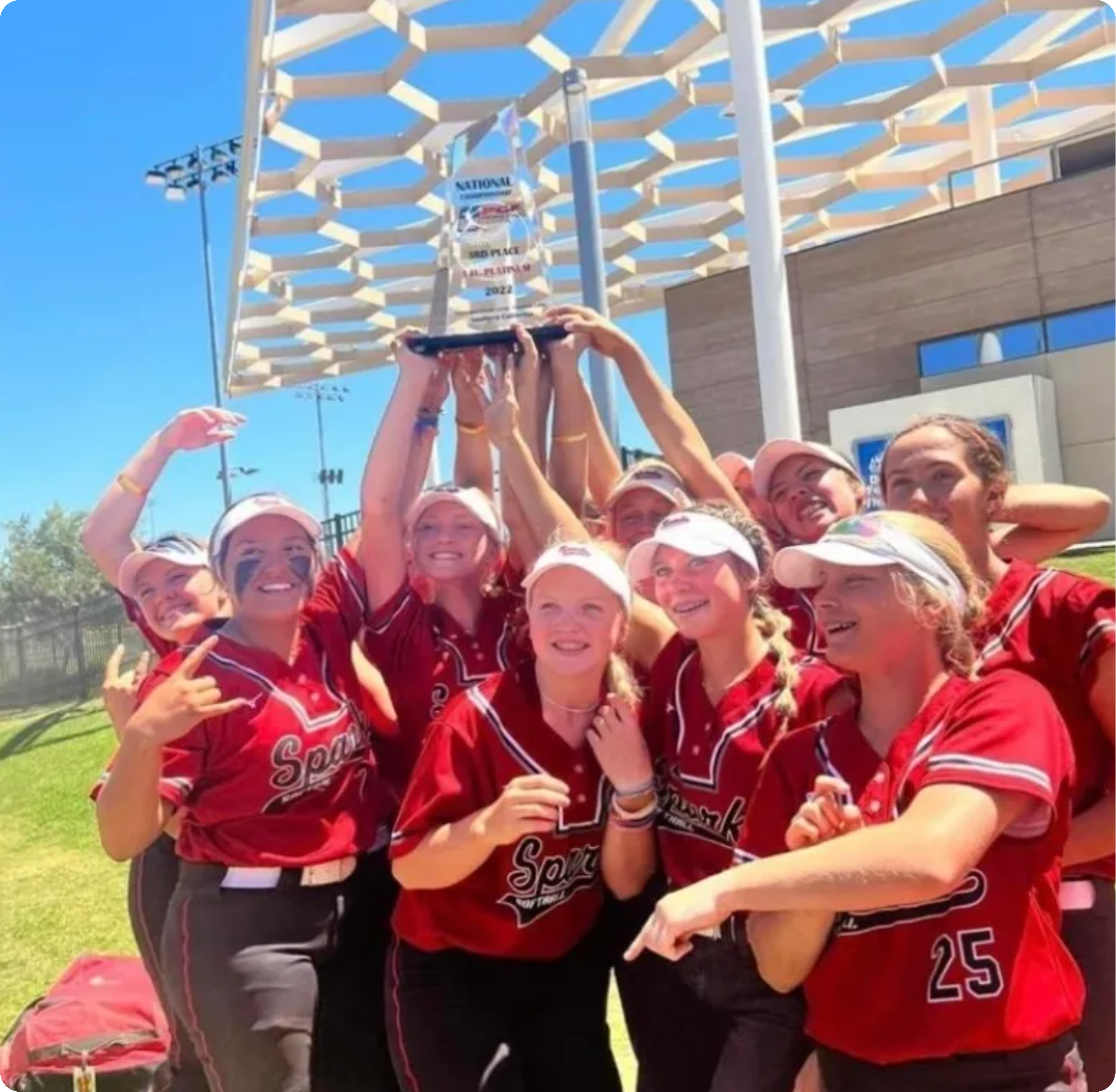 Softball team celebrating with trophy