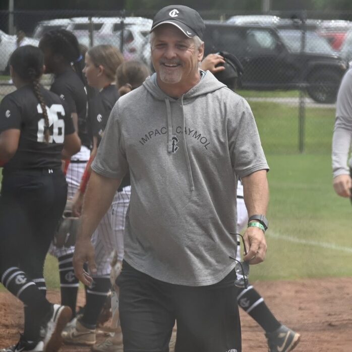 Smiling coach walking on a softball field